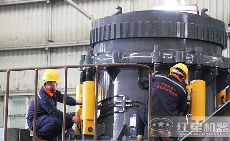 工作人員檢測圓錐破碎機(jī)，保障生產(chǎn)的設(shè)備都有高質(zhì)量